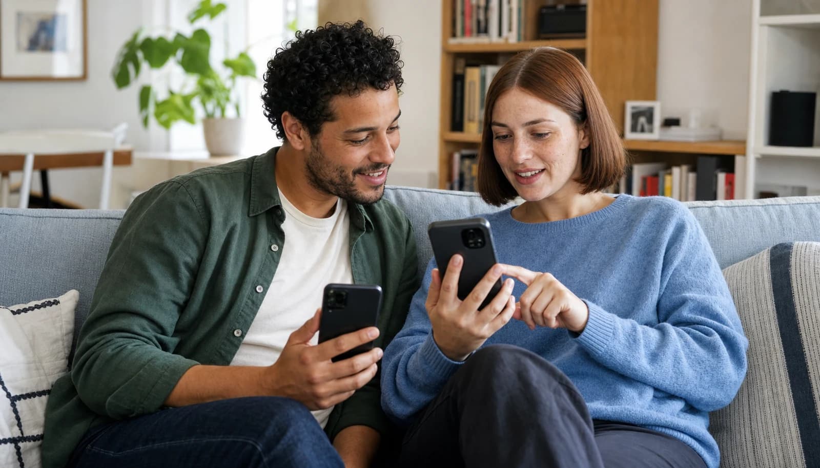 Et par der bruger dating apps sammen i sofaen.